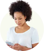 Friendly customer‑support agent with short curls smiles while checking her smartphone.