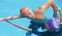 Adult swimmer in an orange cap practising a freestyle arm stretch in the water.