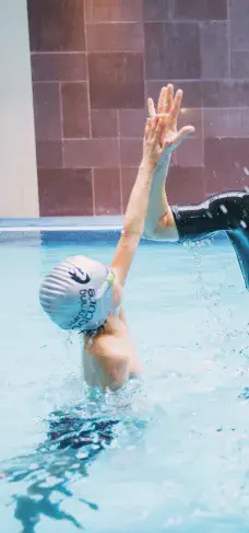 Triptych of fast‑track swimmers — (left) two children in matching caps crouch to dive from the pool edge; (centre) swimmer in a silver cap practises a single‑arm stroke drill; (right) adult in a purple cap and goggles powers forward mid‑freestyle.